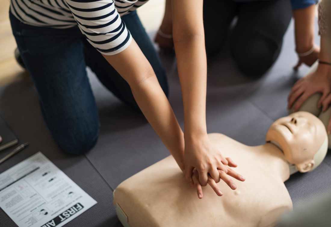person performing cpr on dummy
